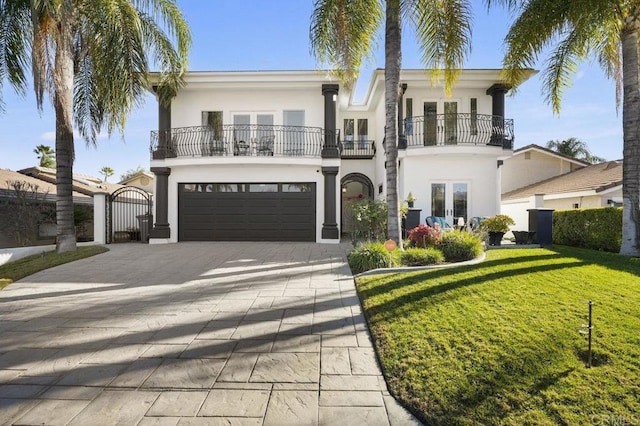 view of front of home featuring a front lawn, a garage, a balcony, and french doors