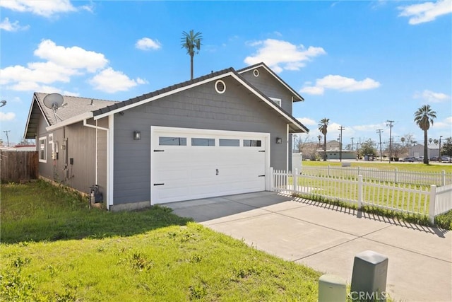 garage with fence and concrete driveway