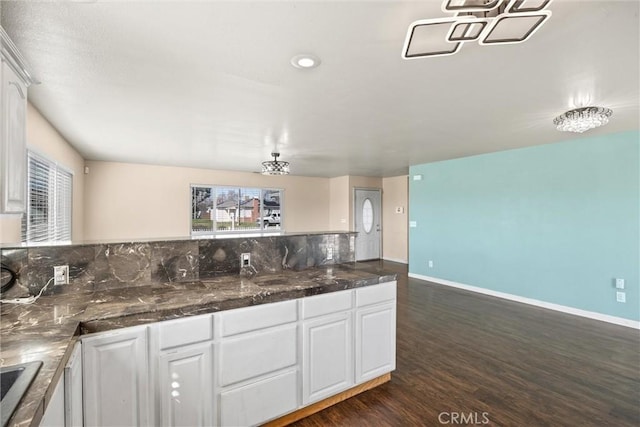 kitchen with dark wood-style floors, baseboards, decorative backsplash, and white cabinets