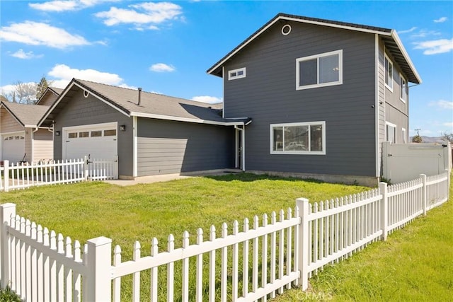 traditional-style house with a garage, a fenced backyard, and a front lawn