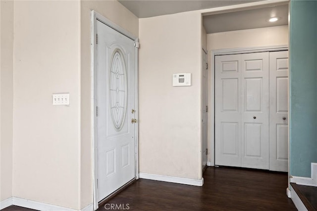 entryway with dark wood-style floors and baseboards