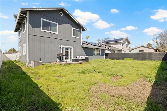 rear view of house with a patio, a lawn, cooling unit, a fenced backyard, and an outdoor living space