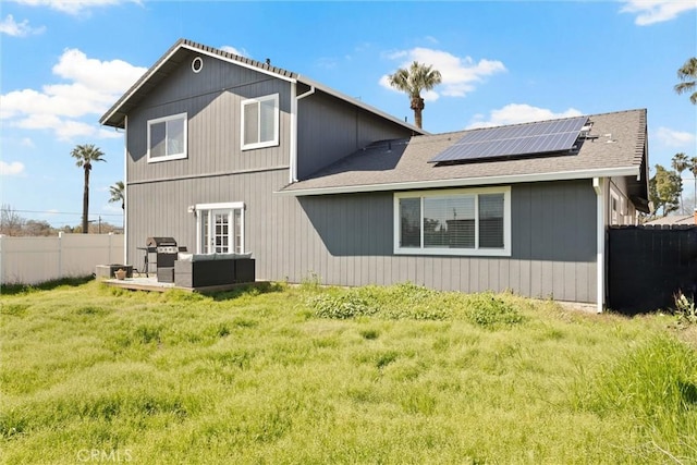 back of house with fence, an outdoor hangout area, solar panels, and a yard