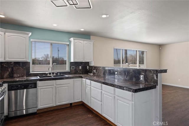 kitchen featuring appliances with stainless steel finishes, plenty of natural light, a sink, and a peninsula