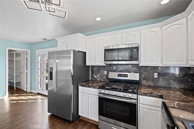 kitchen featuring tasteful backsplash, appliances with stainless steel finishes, white cabinets, and dark wood finished floors