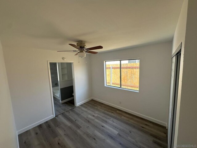 unfurnished bedroom featuring ceiling fan, dark hardwood / wood-style floors, and a closet