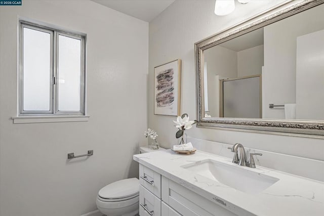 bathroom featuring toilet, a shower with door, and vanity