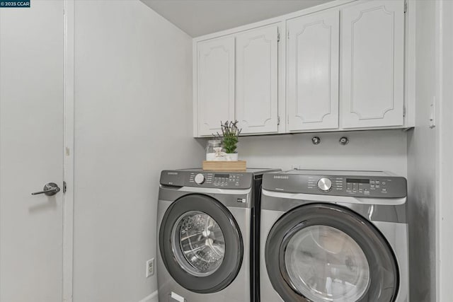 clothes washing area with washer and dryer and cabinets