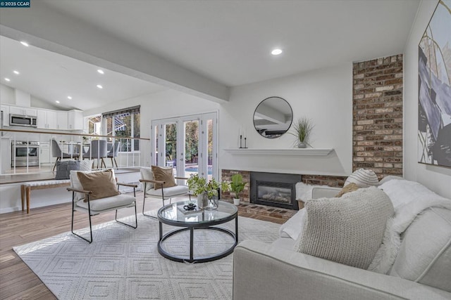 living room featuring light wood-type flooring, french doors, and lofted ceiling with beams