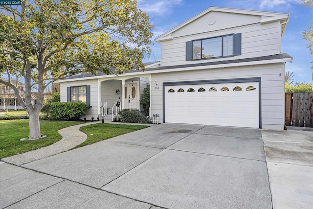 view of property with a garage and a front lawn