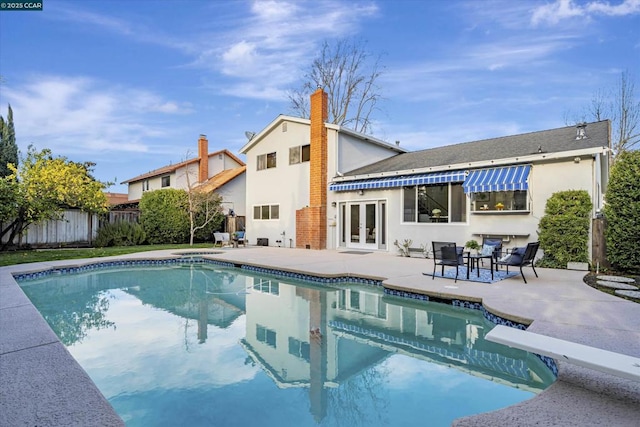 view of pool featuring french doors, a diving board, and a patio area