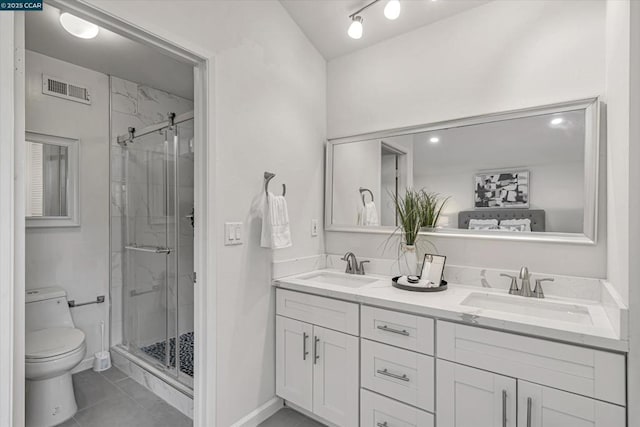 bathroom featuring vanity, a shower with shower door, and toilet