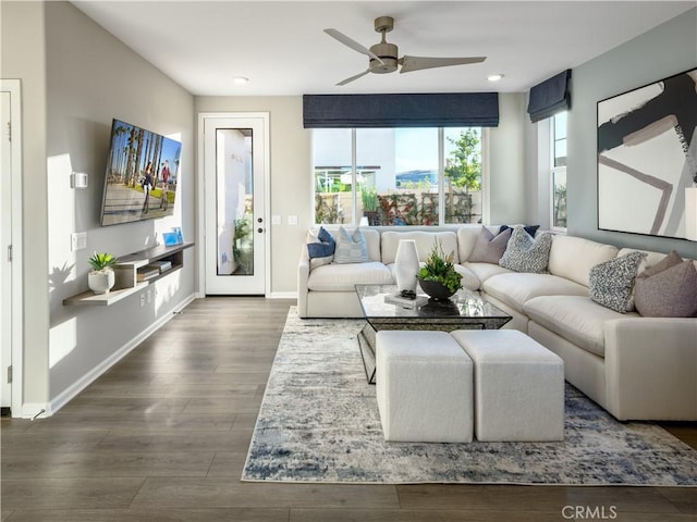 living room with ceiling fan and dark wood-type flooring