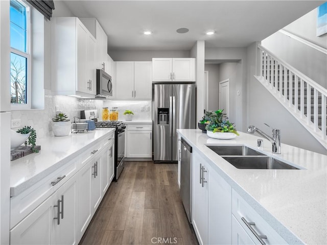 kitchen featuring dark hardwood / wood-style flooring, sink, stainless steel appliances, and white cabinetry