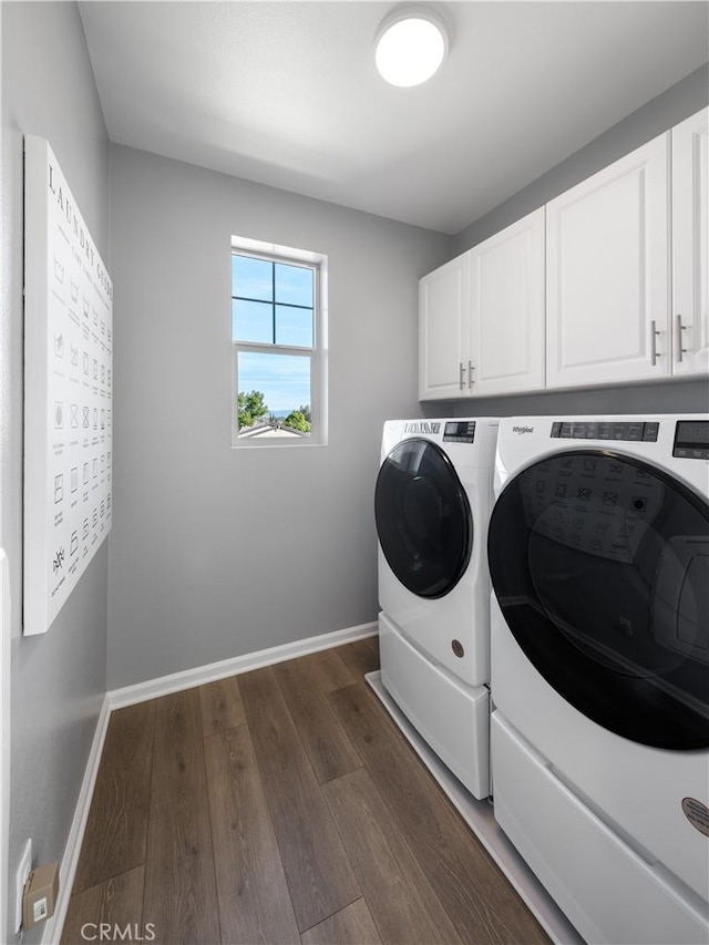 washroom featuring washing machine and dryer, cabinets, and dark hardwood / wood-style floors