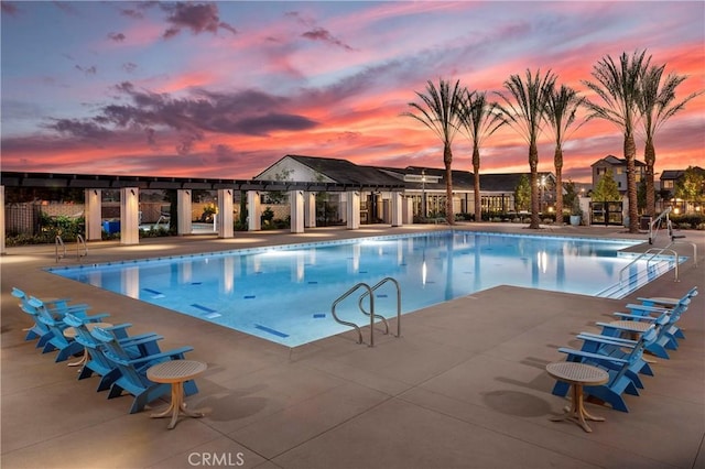 pool at dusk featuring a patio area