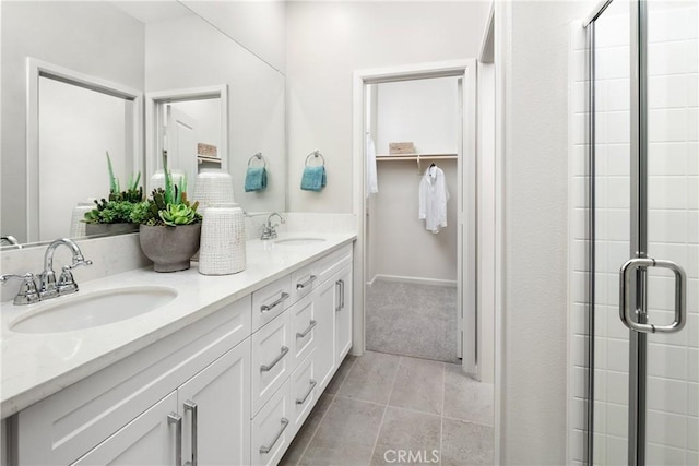 bathroom featuring a shower with shower door, vanity, and tile patterned floors