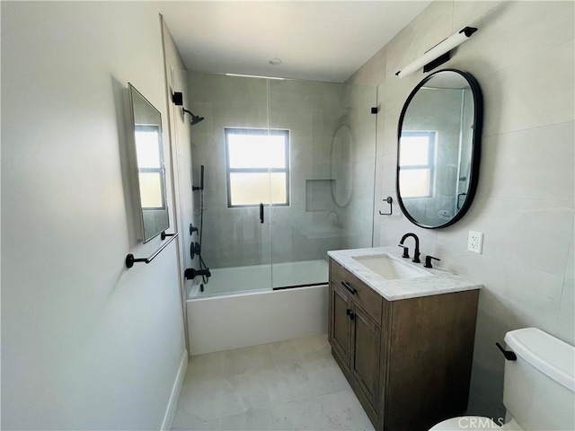 full bathroom featuring vanity, toilet, and combined bath / shower with glass door