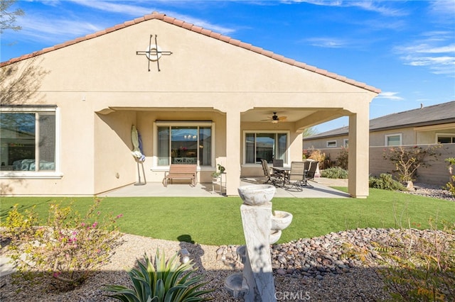 rear view of property featuring a yard, ceiling fan, and a patio area