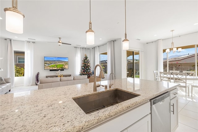 kitchen with white cabinetry, dishwasher, light stone counters, and sink