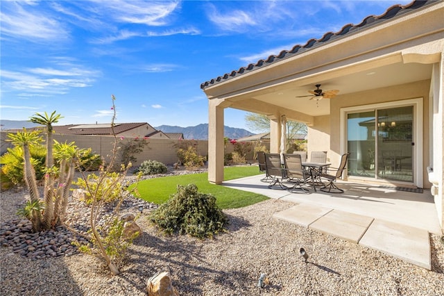 view of yard featuring a mountain view, ceiling fan, and a patio area