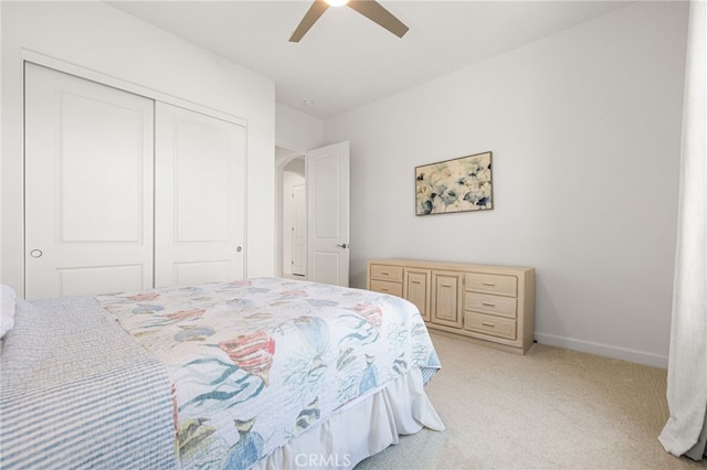 carpeted bedroom featuring a closet and ceiling fan