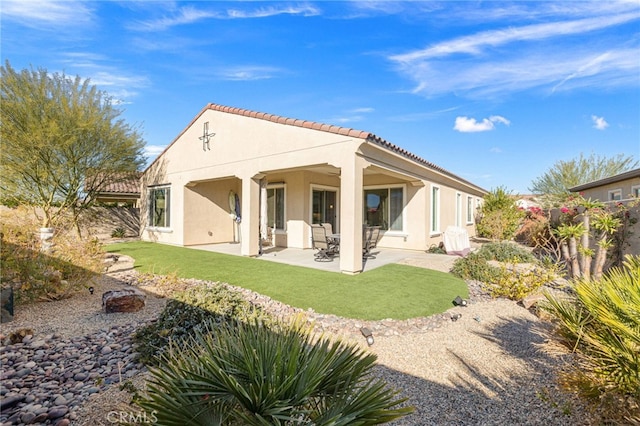 back of property featuring a patio area and a lawn