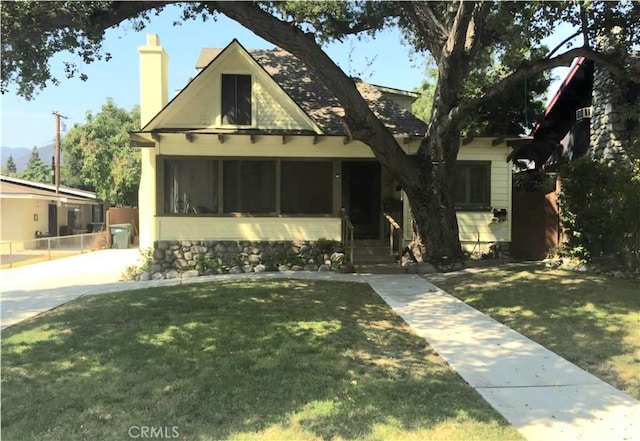 view of front of home featuring a front yard and a sunroom