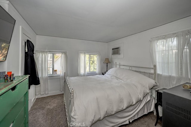 bedroom with dark colored carpet and an AC wall unit