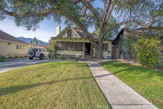 view of front of house featuring a chimney, a front yard, and fence