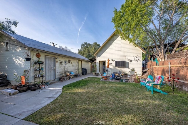 back of house with a patio area, a lawn, and fence