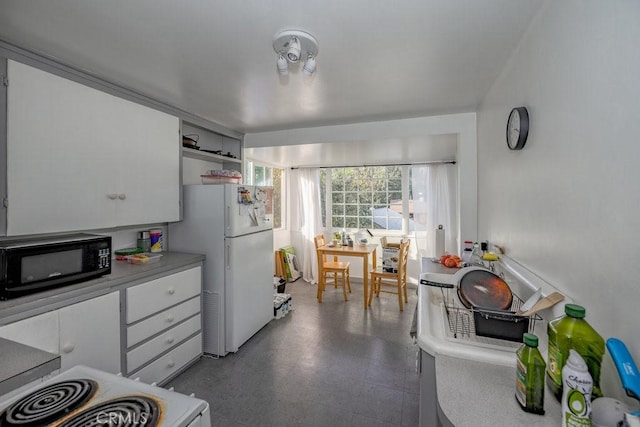 kitchen with dark floors, white appliances, white cabinetry, light countertops, and open shelves