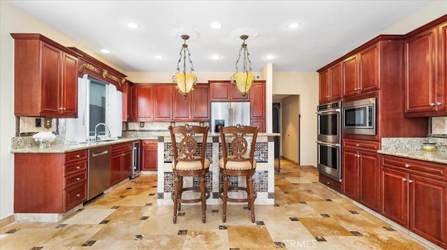 kitchen featuring light stone counters, hanging light fixtures, stainless steel appliances, and tasteful backsplash