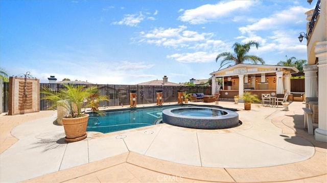 view of pool with a patio area, an in ground hot tub, and an outdoor structure