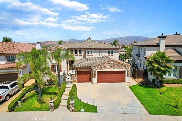 mediterranean / spanish home featuring a front lawn, a garage, and a mountain view