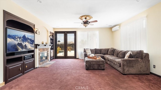 carpeted living room with ceiling fan, a stone fireplace, french doors, and a wall mounted air conditioner