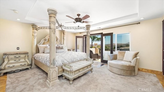 bedroom with ceiling fan and a raised ceiling