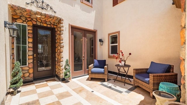 view of exterior entry featuring french doors and a patio