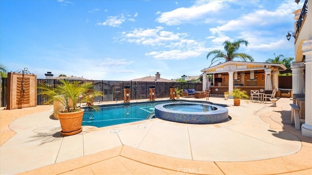 view of pool featuring a patio area and an in ground hot tub