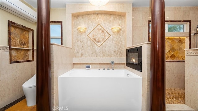 bathroom with toilet, tile walls, a bathtub, and a wall mounted air conditioner