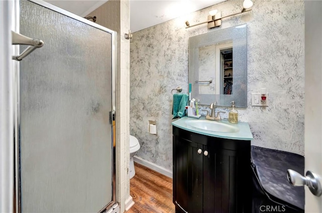 bathroom featuring toilet, walk in shower, hardwood / wood-style floors, and vanity