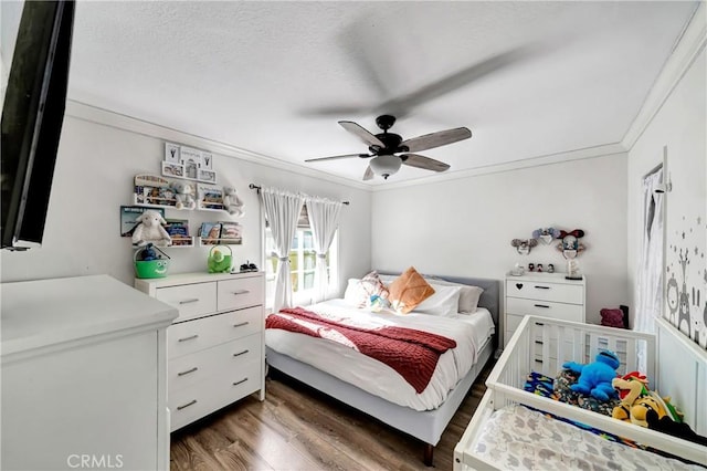 bedroom with ceiling fan, dark wood-type flooring, and ornamental molding