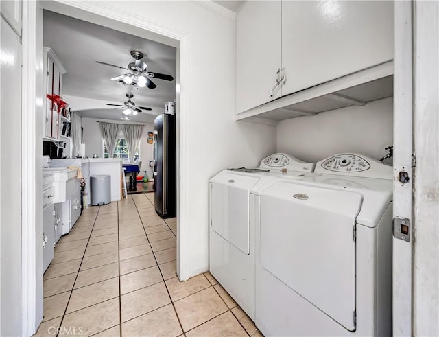 washroom featuring cabinets, light tile patterned flooring, washing machine and clothes dryer, and ceiling fan