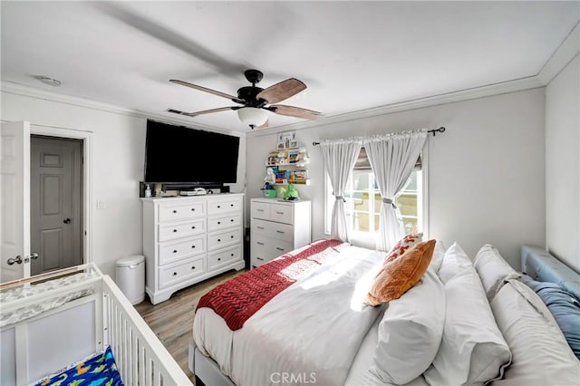 bedroom featuring ceiling fan, ornamental molding, and dark hardwood / wood-style flooring