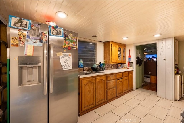 kitchen featuring stainless steel refrigerator with ice dispenser, sink, and backsplash