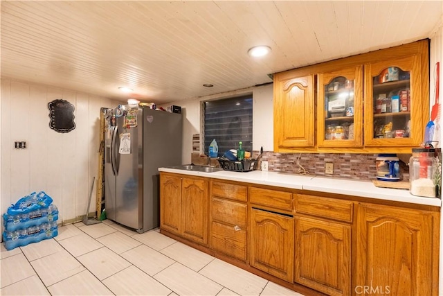 kitchen featuring stainless steel fridge with ice dispenser, backsplash, and sink