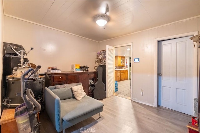 living area with light hardwood / wood-style floors, ornamental molding, and ceiling fan