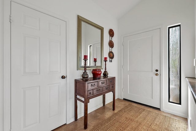 tiled entryway featuring vaulted ceiling