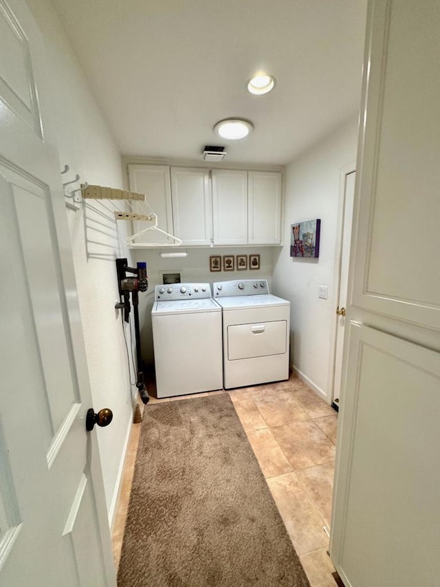 washroom with cabinets, washer and dryer, and light tile patterned floors