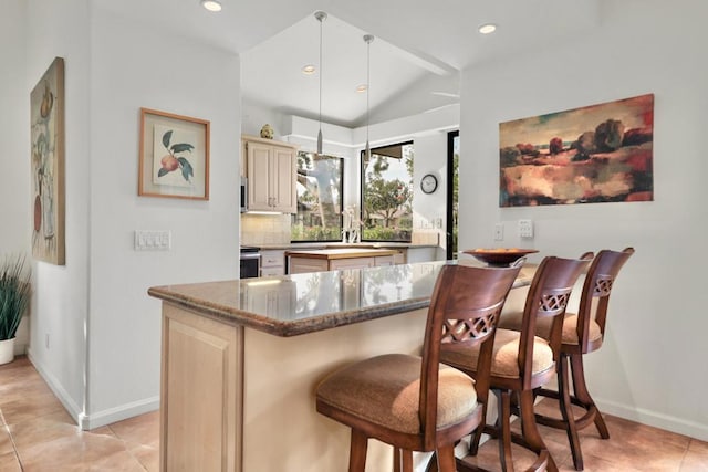 interior space with lofted ceiling, light tile patterned floors, dark stone countertops, decorative backsplash, and decorative light fixtures